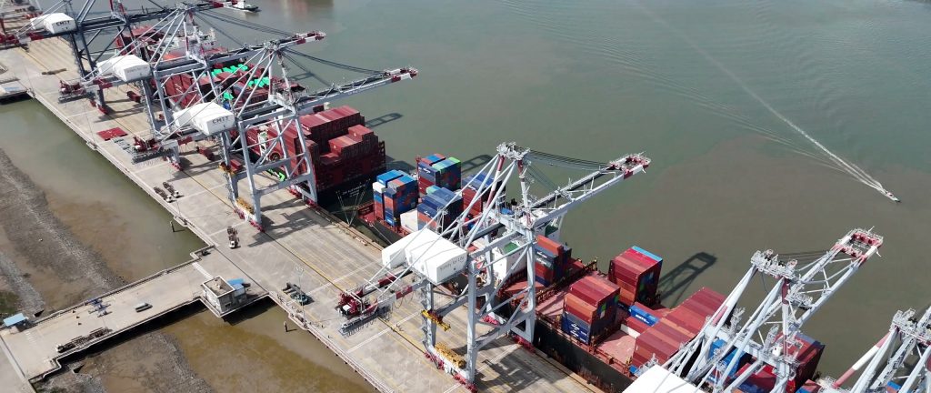 Cần cẩu bốc dỡ container tại một bến cảng ở Hải Phòng, tàu hàng cập cầu cảng bên sông