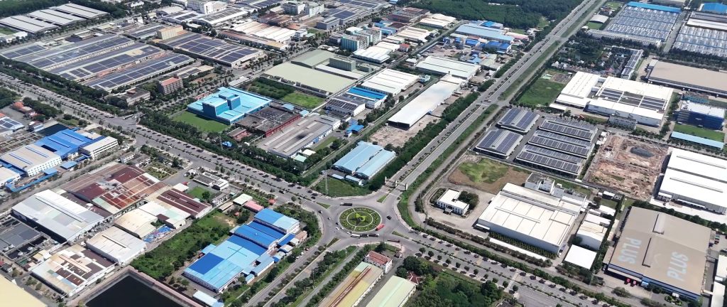 Một khu công nghiệp ở Hải Phòng nhìn từ trên cao với các dãy nhà xưởng mái xanh, đường nội khu và vòng xuyến ở trung tâm