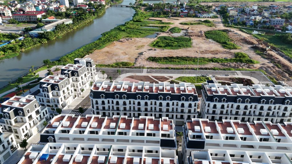 Dãy liền kề phân khu River Park nhìn từ trên cao, phía sau là dòng sông Hòn Ngọc và khu đất trống đang san nền