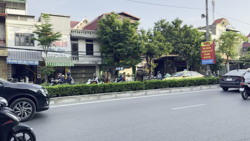 Trục đường chính qua thị trấn Vĩnh Bảo cũ, dải phân cách trồng cây xanh chia hai chiều xe, hai bên là dãy nhà ống và cửa hàng