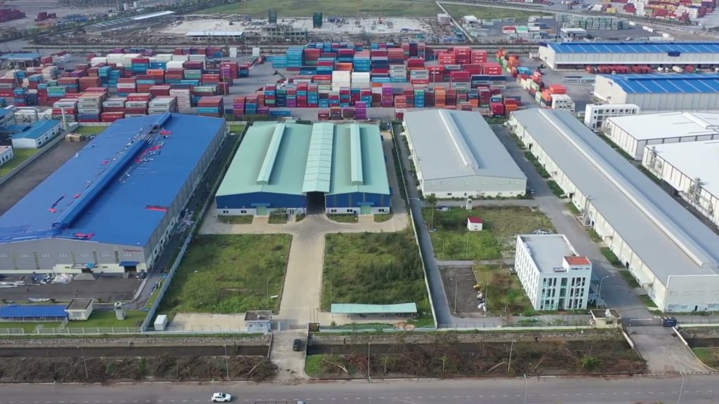 Cảng container Hải Phòng nhìn từ trên cao, các khối container xếp chồng cạnh dãy nhà kho mái xanh