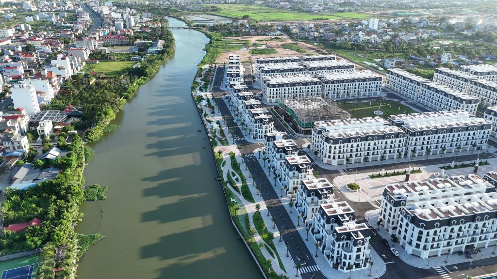 Sông Hòn Ngọc chảy dọc phân khu River Park nhìn từ trên cao, một bên là dãy biệt thự trắng, bên kia là khu dân cư cũ